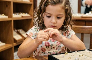 Petite fille essayant une bague argentée dans une bijouterie pour trouver la bonne taille